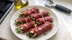 Roladki z wołowiny z rukolą i serem na białym talerzu, kuchnia domowa, zdrowa przekąska