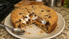 Ciasto czekoladowe z pianką marshmallow, pokrojone na talerzu, na kuchennym blacie.