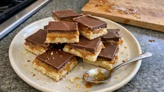 Ciasto milionera z karmelem i czekoladą na talerzu kuchennym