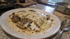 Filet rybny z sosem koperkowym na białym talerzu, domowe danie kuchni polskiej