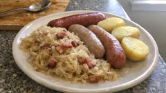 Kiełbasa z kapustą kiszoną i ziemniakami na talerzu, tradycyjne polskie danie