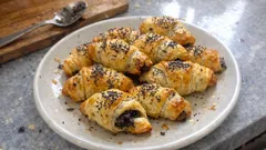 Rogaliki z ciasta francuskiego z makiem na talerzu, przepis na słodkie wypieki domowe.