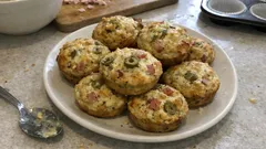 Wytrawne muffiny jajeczne z warzywami i serem na białym talerzu, domowe śniadanie