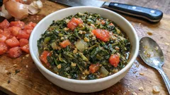 Miseczka sałatki z warzywami liściastymi i pomidorami na drewnianej desce kuchennej.