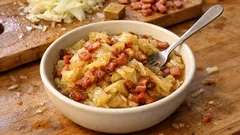 Polska kapusta zasmażana z boczkiem, domowy obiad w misce na drewnianym stole.