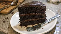 Kawałek czekoladowego tortu na białym talerzu z widelcem, deser, ciasto, słodycze