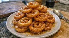 Talerz z tunezyjskimi ciasteczkami makroud, polanymi miodem, na kuchennym blacie