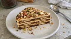 Kawałek ciasta warstwowego z orzechami na talerzu, deser domowy