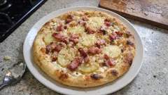 Pizza wiejska na białym sosie: ziemniaki, boczek i gruyère na cienkim cieście