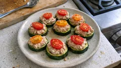 Przekąski z cukinii z pastą i pomidorkiem na białym talerzu, kuchnia domowa.