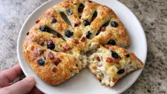 Domowa focaccia z oliwkami i boczkiem na białym talerzu, rustykalne pieczywo