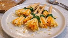 Przekąski na Halloween przypominające miotełki, z sera i paluszków, na białym talerzu.