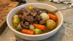 Gulasz wołowy z warzywami, ziemniakami, marchewką i selerem w misce na stole.