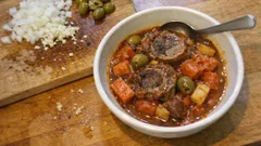 Pręga wołowa duszona w pomidorach z marchewką i zielonymi oliwkami – miękka jak masło