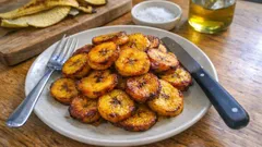 Smażone platany na talerzu, gotowe do jedzenia, widelczyk i nóż obok