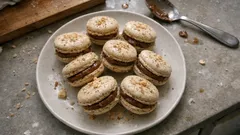 Francuskie makaroniki pistacjowe na białym talerzu, deser na szarym tle