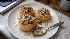 Paszteciki z ciasta francuskiego z farszem grzybowym na talerzu kuchennym