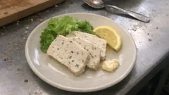 Talerz z tofu, sałatą, plasterkiem cytryny i majonezem na stole kuchennym