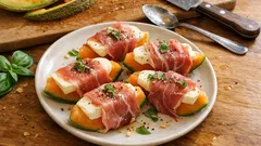 Melon z szynką parmeńską i mozzarellą na talerzu, podany na drewnianym stole.