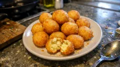 Kuleczki serowe smażone na złoto na talerzu, domowa przekąska na imprezę