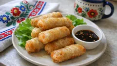 Sajgonki z warzywami na talerzu z sosem sojowym i sałatą, tradycyjny obrus w tle.