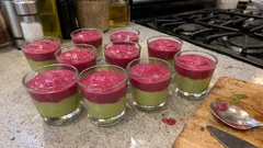 Deser w szklankach z zieloną warstwą i różową pianką na kuchennym blacie